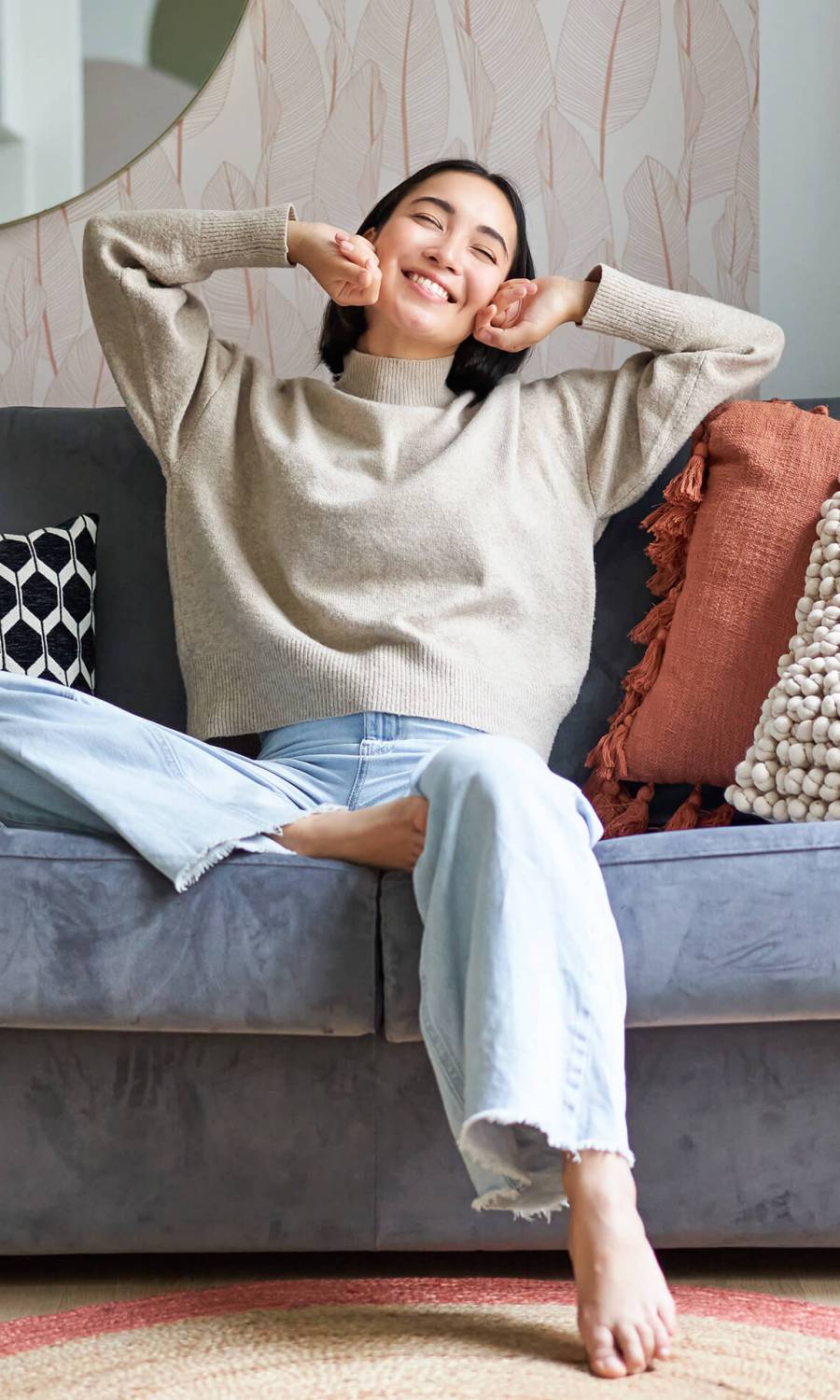 Portrait of happy asian woman feeling lazy, stretching on sofa and smiling pleased, relaxing at home, resting from work Portrait of happy asian woman feeling lazy, stretching on sofa and smiling pleased, relaxing at home, resting from work.